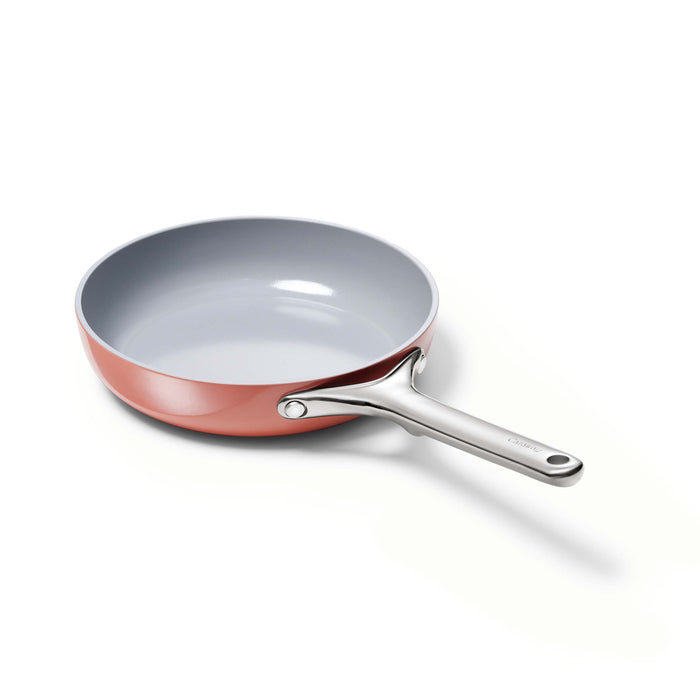 A ceramic nonstick frying pan with a light gray interior, shiny silver handle, and copper-colored exterior, placed on a white background.