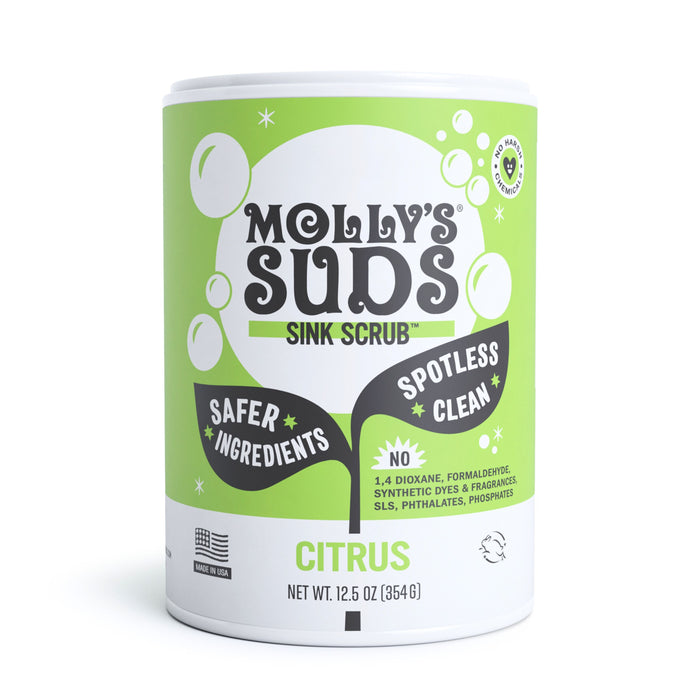 A container of Mollys Suds Sink Scrub in citrus scent, featuring green and white packaging with text highlighting “safer ingredients,” “spotless clean,” and “no 1,4 dioxane, formaldehyde, synthetic dyes & fragrances.”.