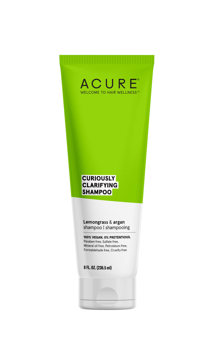 A green and white tube of ACURE Curiously Clarifying Shampoo with lemongrass and argan, labeled 100% vegan, sulfate-free, and cruelty-free. The tube holds 8 fl oz (236.5 mL).