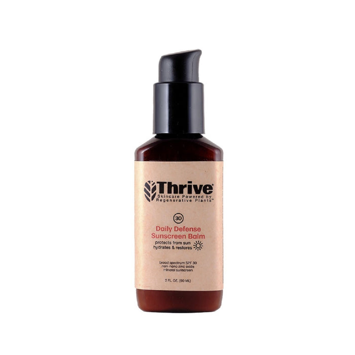 A brown bottle of Thrive Daily Defense Sunscreen Balm with a black pump cap and tan label. The label highlights SPF 30 protection, hydration, and restoration. The bottle contains 3 fl oz (90 mL).