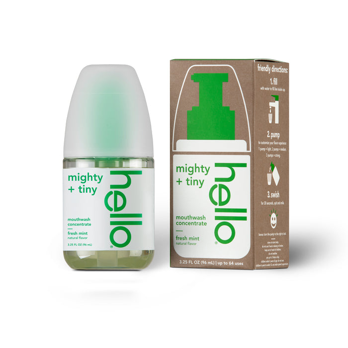 A small bottle of Hello Mighty + Tiny Fresh Mint mouthwash concentrate stands next to its brown and green box, which displays directions and a green pump graphic.