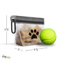The (re)zip Airtight Pet Treat Bag + Carabiner, filled with treats and featuring a black paw print design, sits by a yellow tennis ball. Perfect leash accessory. Measures 3 3/4" tall, 6 1/4" wide, and 2" deep.