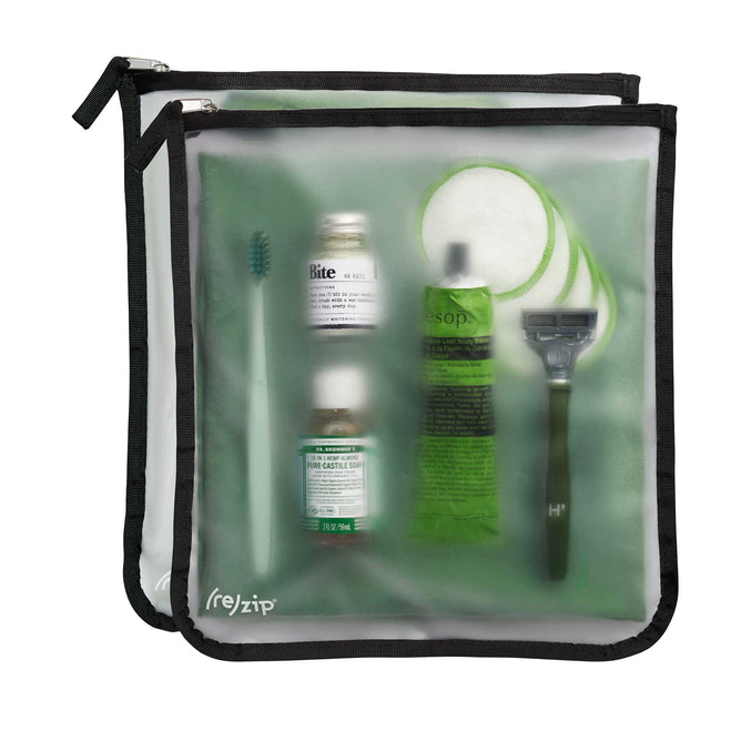 The (re)zip Travel Organizer Zipper Bags - Large features a transparent reusable gallon bag with a toothbrush, two small bottles, cream tube, cotton rounds, and black razor—ideal for organized travel storage.