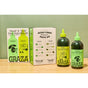 Graza’s The Duo Drizzle and Sizzle Olive Oil Gift Set—featuring two green bottles labeled Drizzle and Sizzle alongside a coordinating box with product details—rests on a light wood surface against a soft green wall, making it an appealing gift for gourmet condiment enthusiasts.