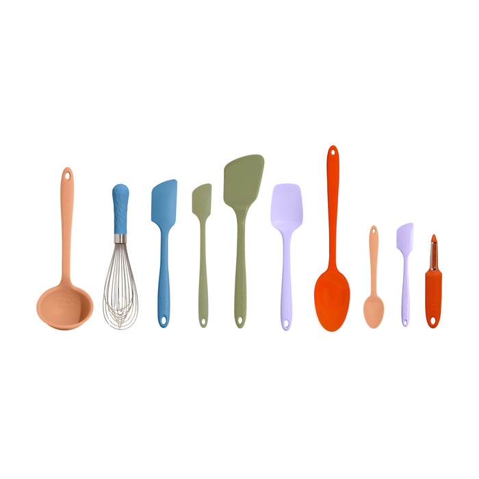 A row of colorful kitchen utensils, including a ladle, whisk, four spatulas of various sizes, a spoon, a small brush, a small spatula, and a vegetable peeler, all arranged on a white background.