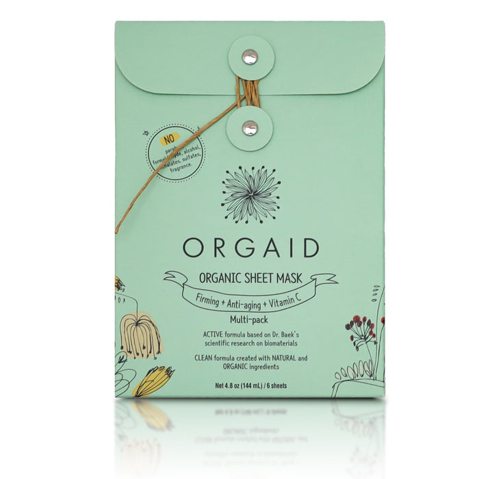 A mint green Orgaid Organic Sheet Mask box with a string-tie closure, featuring floral illustrations and labeled as firming, anti-aging, vitamin C, and containing six sheets.