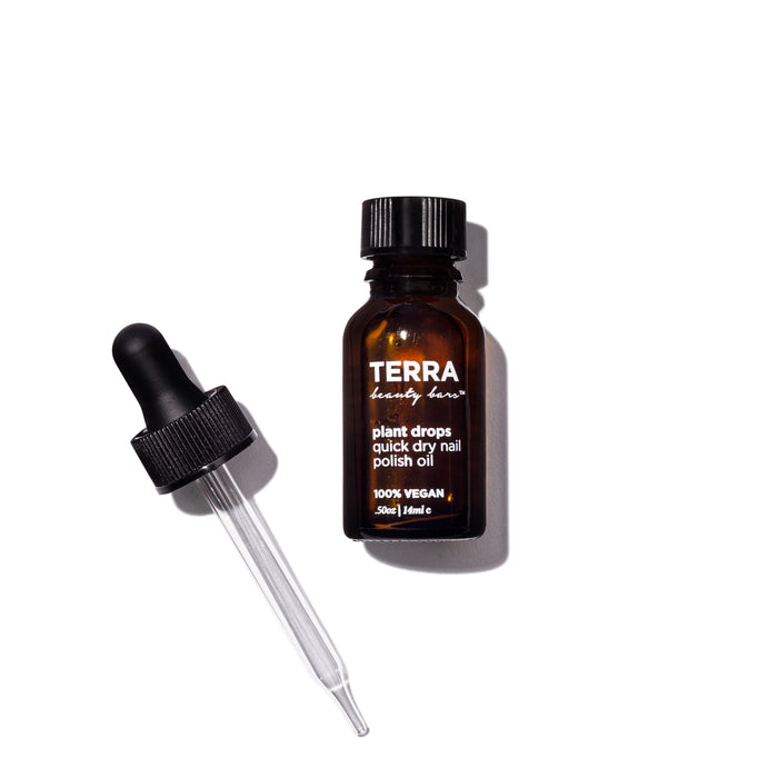 A brown glass bottle labeled TERRA beauty bars Plant Drops Quick Dry Nail Polish Oil with a black dropper cap lying beside it on a white background.
