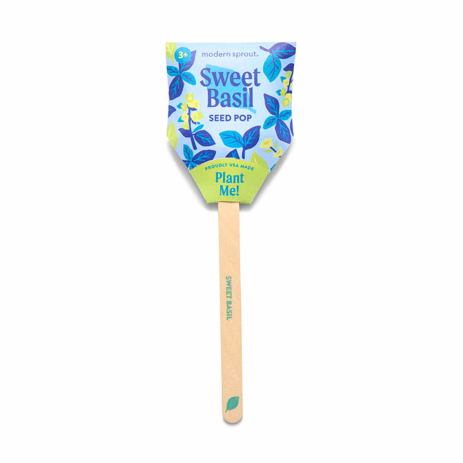 The Modern Sprout Seed Pop is a family-friendly gardening tool in vibrant packaging with blue and green leaf designs. It contains organic seeds, featuring Sweet Basil Seed Pop, Plant Me! text, and a wooden stick marked Sweet Basil.