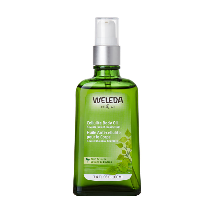 A green glass bottle of Weleda Cellulite Body Oil with a white pump dispenser, featuring a label with English and French text and leaf graphics, containing 3.4 fl oz (100 ml).