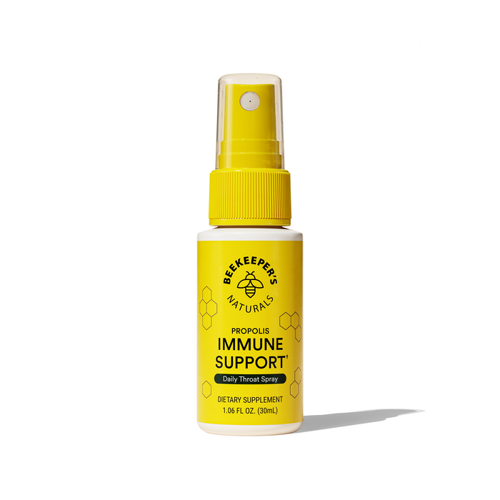 A yellow spray bottle labeled Beekeepers Naturals Propolis Immune Support, Daily Throat Spray, Dietary Supplement, 1.06 fl oz (30 ml) with a bee logo and honeycomb design, against a white background.