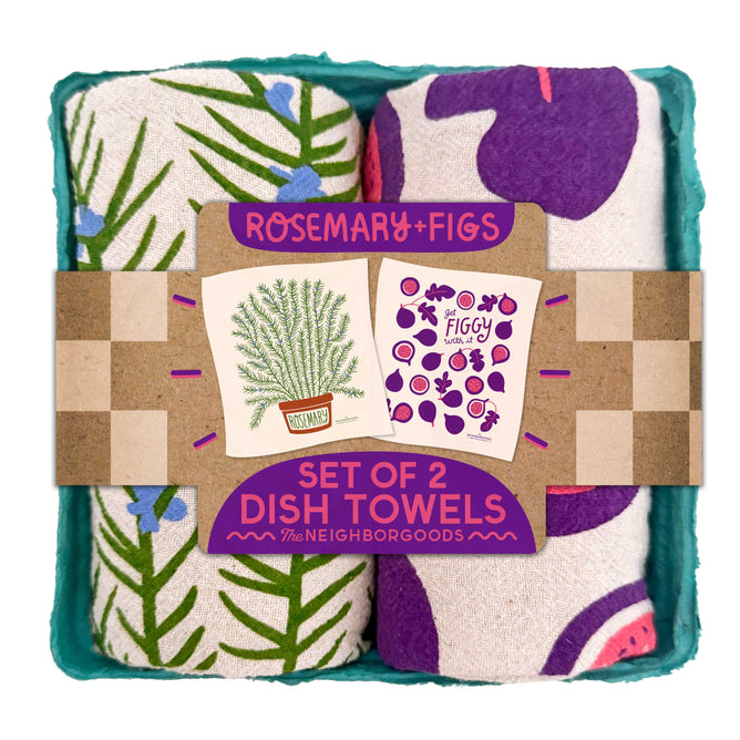 The Neighborgoods Dish Towel Set includes two rolled cotton towels—one with a rosemary leaf design and one with figs—displayed in a turquoise tray. Perfect for adding style to any kitchen.
