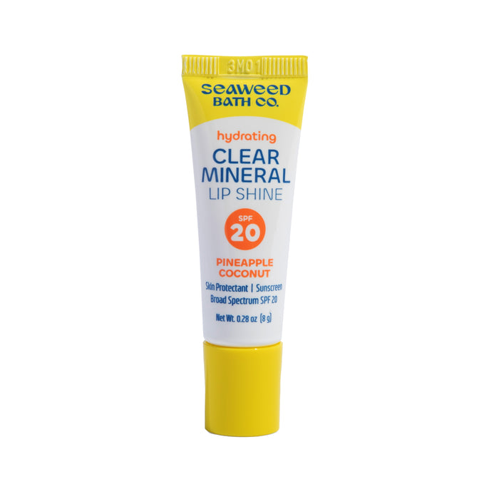 A yellow tube of Seaweed Bath Co. Hydrating Clear Mineral Lip Shine in Pineapple Coconut flavor, SPF 20, with blue, orange, and white text on the front.