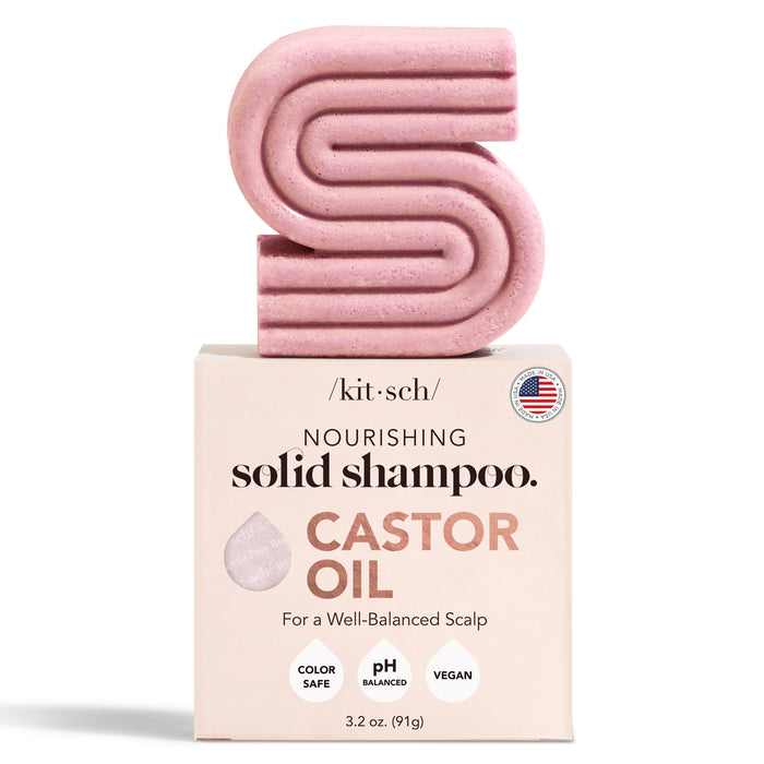A pink, S-shaped solid shampoo bar sits on a box labeled “Nourishing Solid Shampoo. Castor Oil. For a Well-Balanced Scalp.” Box notes: color safe, pH balanced, vegan. Brand: Kitsch. Size: 3.2 oz (91g).