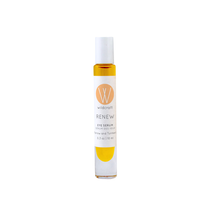 A clear glass roller bottle filled with yellow liquid, labeled Wildcraft Renew Eye Serum with a white cap, displayed on a white background.