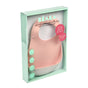 A boxed set of two BEABA silicone bibs, one pink and one white, displayed in mint green packaging with French and English text. The bibs have a front pocket and are labeled as “not a crumb is lost!”.