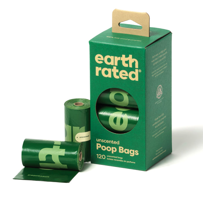 A green box labeled earth rated unscented poop bags with three green rolls of dog waste bags, one partially unrolled, next to the box. The box contains 120 unscented bags and has a handle on top.