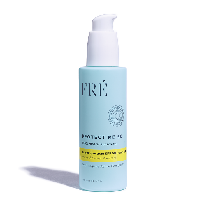 A light blue bottle of FRÉ Protect Me 50 Mineral Sunscreen with a white pump dispenser, featuring SPF 50 and broad spectrum UVA/UVB protection, water and sweat resistance, and Argania Active Complex.
