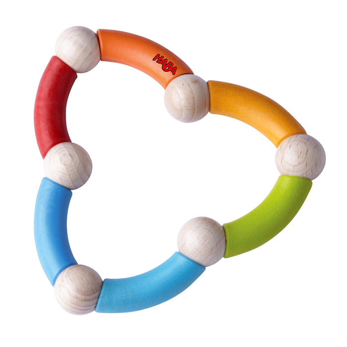 Colorful wooden baby teether with six curved segments in red, orange, yellow, green, and blue, connected by round wooden beads, forming a flexible ring. The HABA logo is printed on the orange segment.