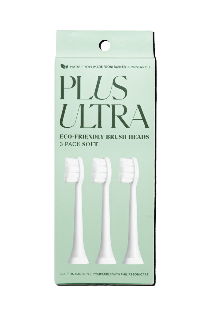A mint green box labeled PLUS ULTRA containing three white eco-friendly toothbrush heads, compatible with Philips Sonicare. The packaging highlights that it is soft and made from cornstarch.