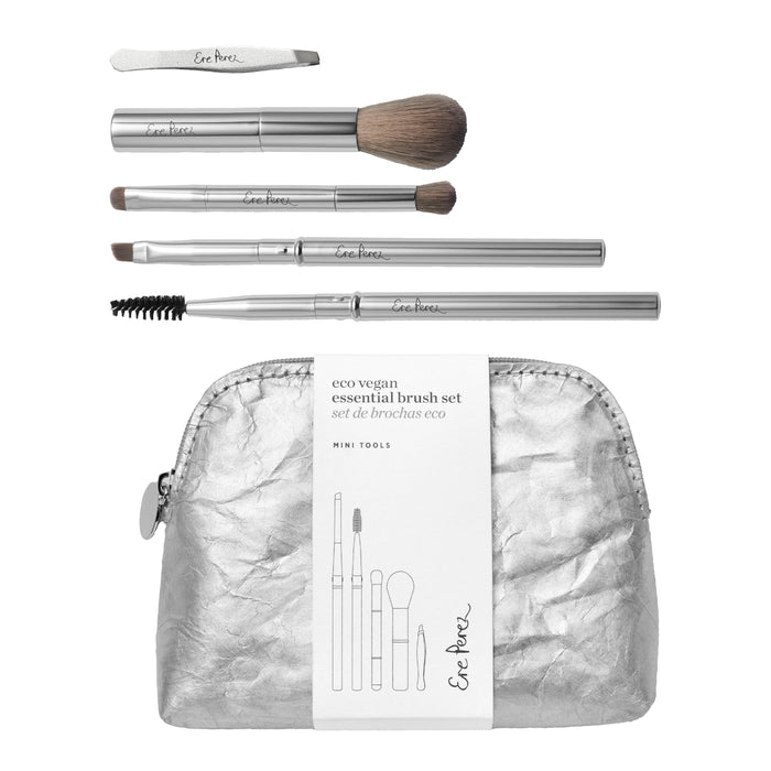 A silver makeup bag with a white label is displayed with five eco vegan makeup brushes and tools, including a nail file, powder brush, eye brush, lip brush, and spoolie, all with silver handles.