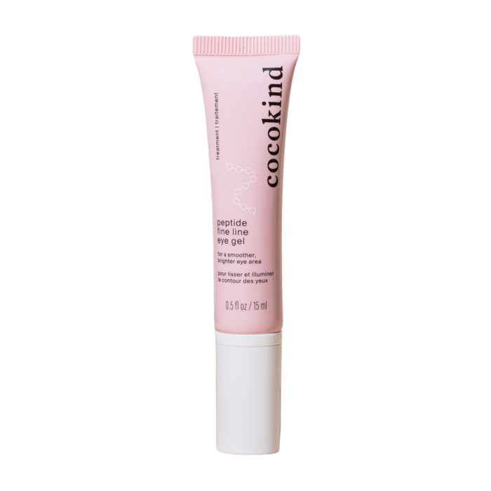 A pink tube of Cocokinds Peptide Fine Eye Gel with a white cap highlights its benefits as a treatment for fine lines and a hydrating blend to promote smoother, brighter skin around the eyes. The tube is 0.5 fl oz (15 ml).
