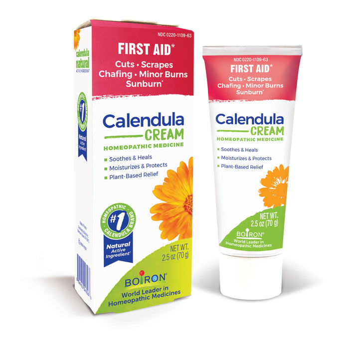 A tube and box of Boiron Calendula Cream for first aid, labeled for cuts, scrapes, chafing, minor burns, and sunburn. Packaging features a yellow flower and states its homeopathic, plant-based, and net weight is 2.5 oz (70g).