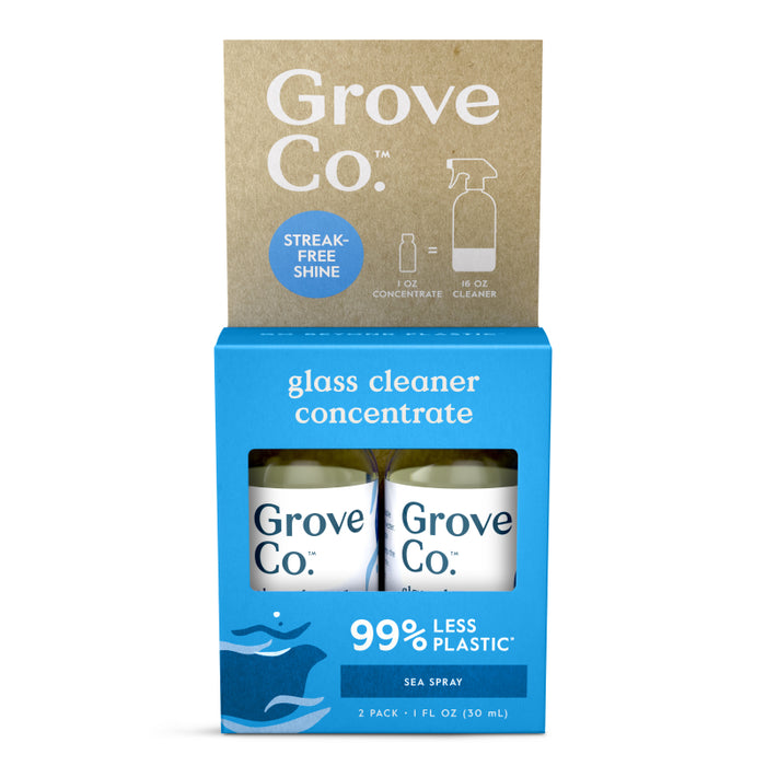 Two bottles of Grove Co. glass cleaner concentrate in a blue and brown box, labeled sea spray and 99% less plastic. The packaging also notes streak-free shine and shows the contents as 2 pack, 1 fl oz each.