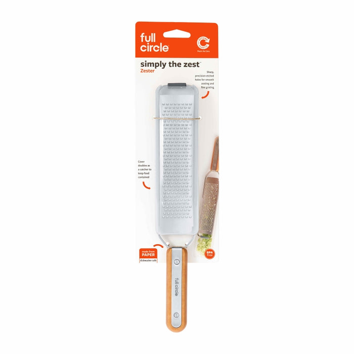 A Full Circle brand zester in its packaging, featuring a stainless steel grating surface and a wooden handle. The label reads simply the zest and shows a photo of the zester in use with citrus fruit.