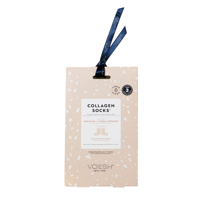 A beige package labeled Collagen Socks with argan oil and floral extracts by VOESH New York, featuring a dark ribbon loop at the top for hanging and small white speckle patterns on the packaging.