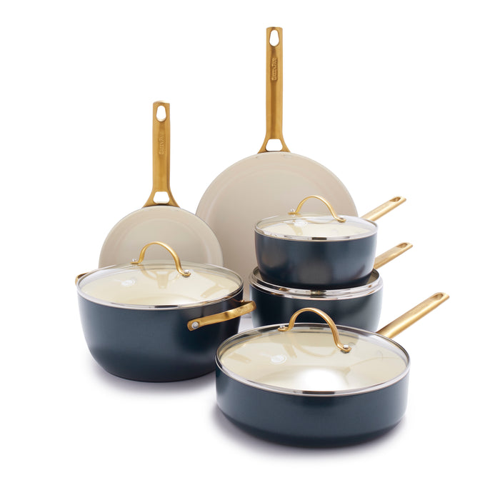 A set of nonstick cookware with gold handles, including two frying pans, two saucepans with lids, a sauté pan with lid, and a Dutch oven with lid, all in a dark blue color with cream interiors.
