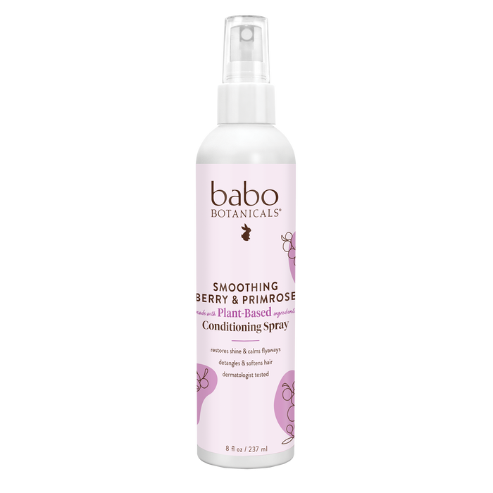 A white spray bottle of Babo Botanicals Smoothing Berry & Primrose Plant-Based Conditioning Spray, featuring pink accents and text describing its use to detangle, soften, and smooth hair. The bottle is 8 oz (237 ml).