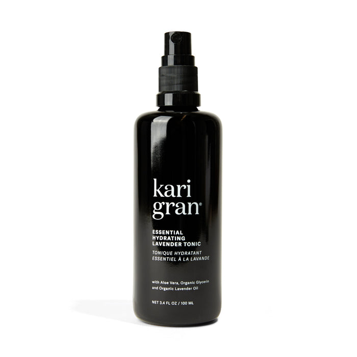 A black spray bottle labeled kari gran ESSENTIAL HYDRATING LAVENDER TONIC with details about aloe vera, organic glycerin, organic lavender oil, and a volume of 3.4 fl oz (100 mL).