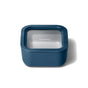 A square, blue food storage container with a clear lid and the word Caraway printed on top, shown on a white background.