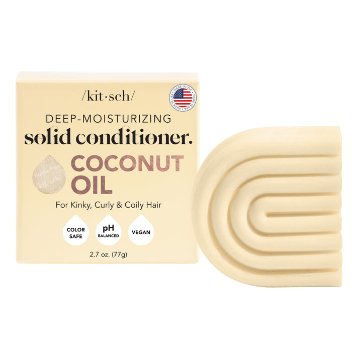 A box of Kitsch deep-moisturizing solid conditioner with coconut oil for kinky, curly, and coily hair is shown beside the solid conditioner bar, which is beige and has a curved, geometric design.