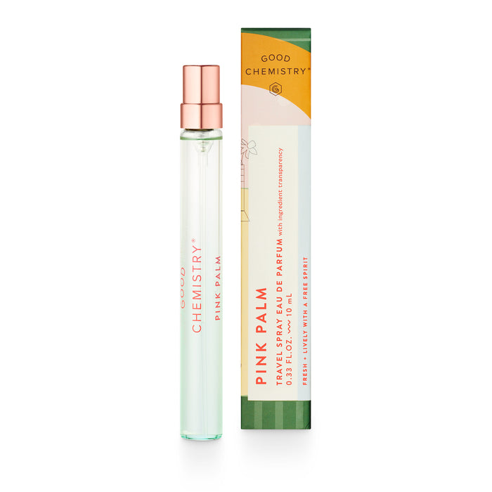 A Good Chemistry Pink Palm perfume roller in a slim, clear glass bottle with a pink cap stands next to its colorful rectangular box featuring orange, pink, and green accents.