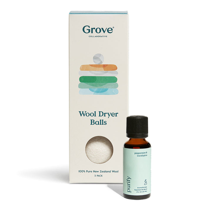 A Grove Co. Wool Dryer Balls box featuring pastel geometric shapes sits next to a small dark bottle labeled Purify, highlighting all-natural peppermint and eucalyptus essential oils with a green label.