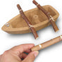 The HABA Terra Kids Cork Boat DIY Activity Kit (award winning, ages 5+) includes a cork boat with two wooden oars attached to its sides and a third stick held in a hand in the foreground.