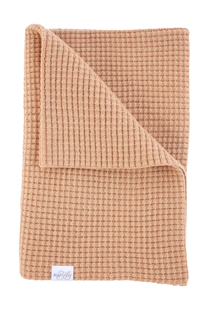 Folded terracotta-colored waffle-knit The Popcorn - Henna heirloom baby blanket made from superfine merino wool.