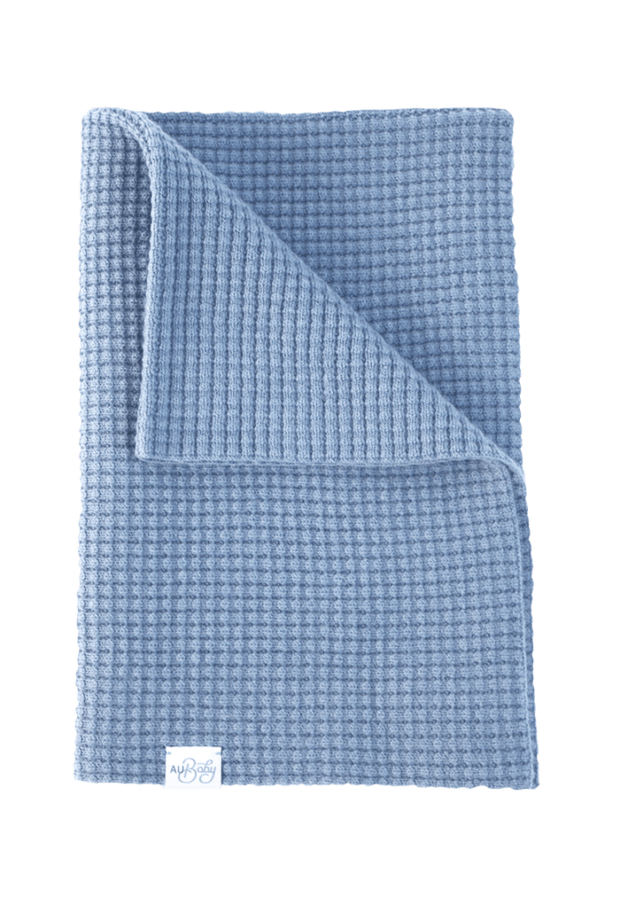 Sky Blue The Popcorn Blanket in light blue superfine merino with a textured waffle pattern, folded over at the top corner.