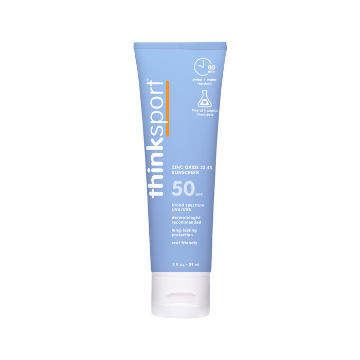 A light blue tube of thinksun thinksport SPF 50 mineral sunscreen with white text highlighting broad spectrum, zinc oxide, and reef-friendly for sensitive skin, stands upright on a white backdrop.