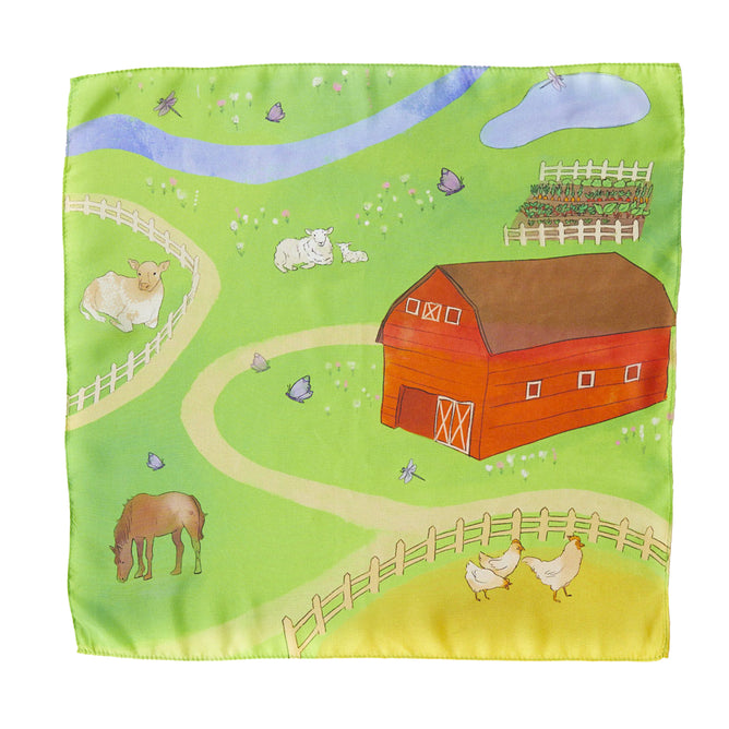 The Play Map by Sarahs Silks features an illustrated farm scene on playsilk fabric with a red barn, a cow, a horse, two chickens, and a sheep. It includes elements like a river, pond, butterflies, dragonflies, vegetable garden, and paths—ideal for Montessori-inspired play.