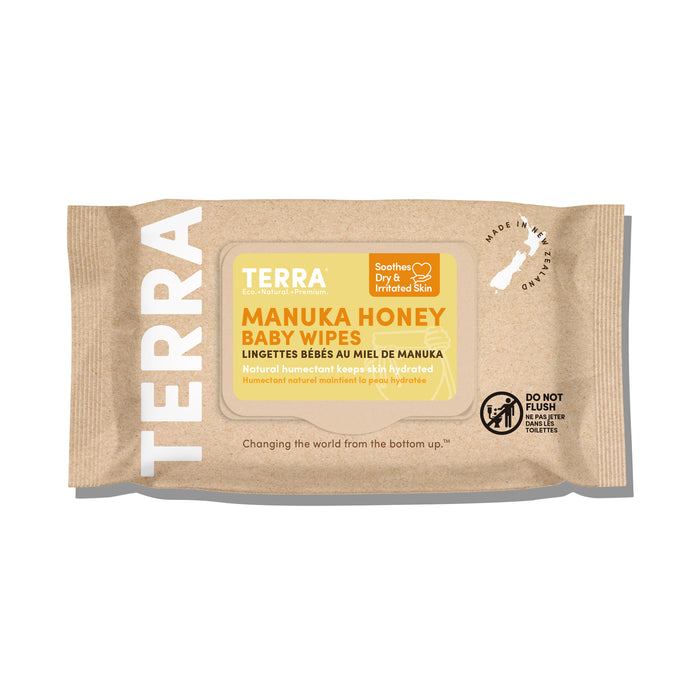 Package of Terra Baby Wipes - Manuka Honey against a beige background; moisturizing properties soothe dry, sensitive skin. Label advises not to flush. The package has a map silhouette and the logo Changing the world from the bottom up.