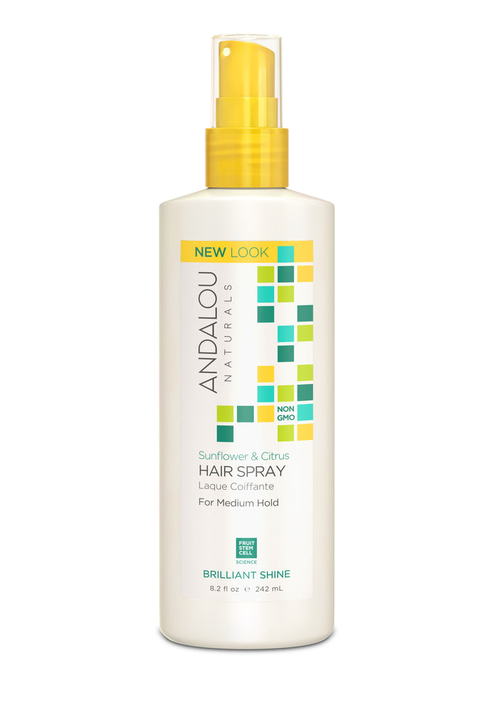 A white bottle of Andalou Naturals Sunflower & Citrus Hair Spray with a yellow spray cap, featuring green, blue, and yellow square designs and product details on the front label.