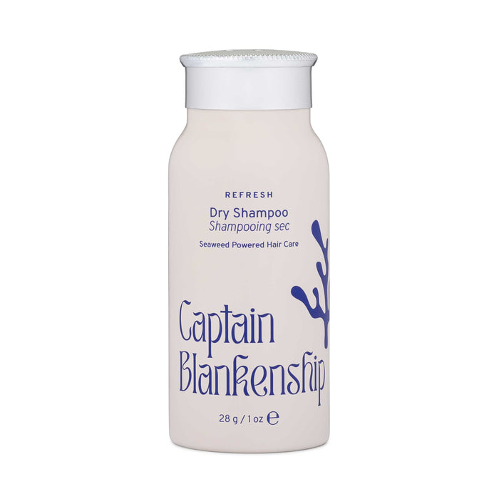 A white bottle of Captain Blankenship Dry Shampoo with purple text and a seaweed graphic on the front. The label mentions Seaweed Powered Hair Care and the bottle contains 28 grams or 1 ounce of product.