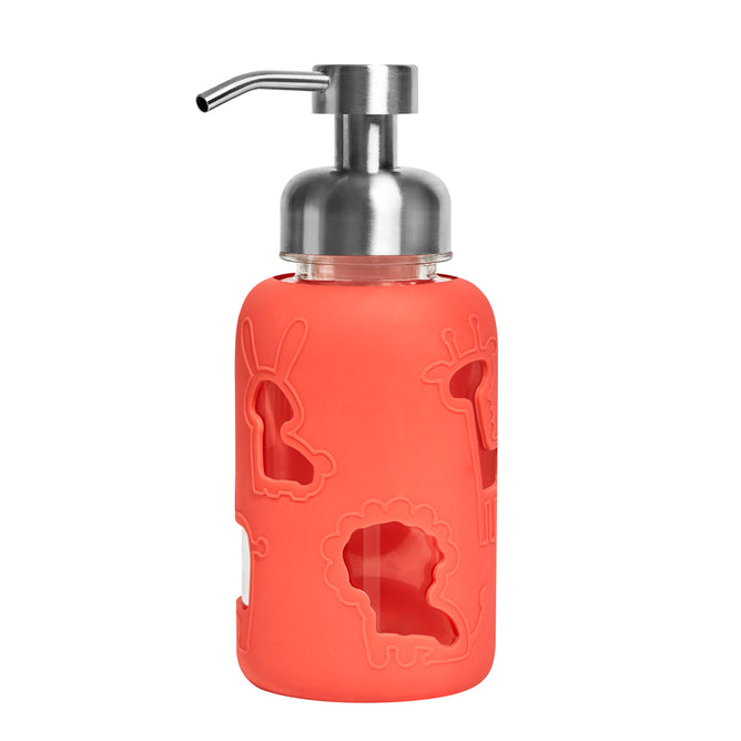 The Grove Co. Kids Foaming Hand Soap Glass Dispenser features a reusable glass container with a stainless steel pump and a red silicone sleeve with cut-out animal shapes, like a lion, giraffe, and rabbit, combining charm with reduced plastic waste.