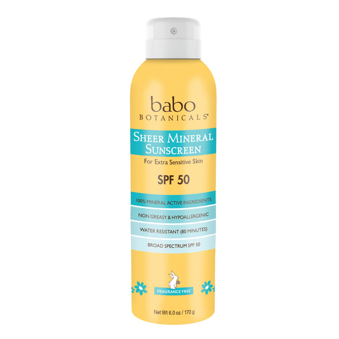 A yellow and white spray can of Babo Botanicals Sheer Mineral Sunscreen SPF 50, labeled for extra sensitive skin, with turquoise accents and flowers, and text stating it is water resistant, non-greasy, and fragrance free.