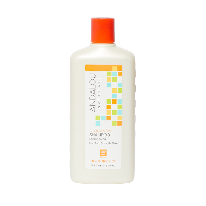 The image showcases a 340 ml white bottle of Andalou Naturals Moisture Rich Argan Oil & Shea Shampoo with an orange cap. The label features a colorful grid design, highlighting Moisture Rich benefits, infused with argan oil, shea for softness and shine, plus the rejuvenating fruit stem cell complex.