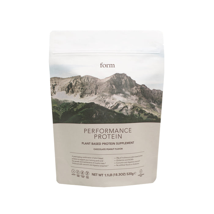 A bag of Form Performance Protein, a plant-based protein supplement in chocolate peanut flavor. The packaging features a mountain landscape and product details on a white and beige background.