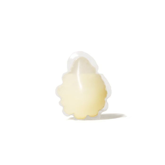Set against a white background, the Dew Bomb Glowy Hydra-Milk Refill from IZZY Zero Waste Beauty is a translucent patch with scalloped edges and a pale yellow tint, appearing smooth and slightly raised.