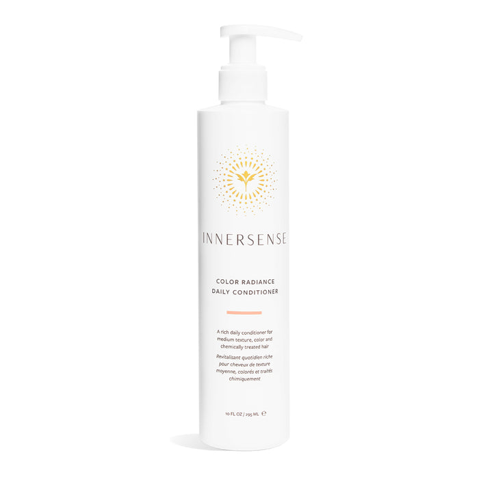A white pump bottle of Innersense Color Radiance Daily Conditioner with gold sunburst logo and text, designed for medium textures, color and chemically treated hair. The bottle holds 10 fl oz (295 ml).